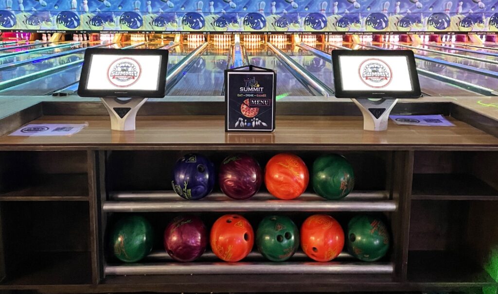 Summit Entertainment Bowling Kiosk with ball rack and lanes in the background